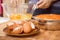 Woman is scattering chicken eggs lying in a glass bowl.