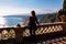 Woman with scenic view on snow capped Mount Etna volcano on sunny day from public garden Parco Duca di Cesaro in Taormina Sicily