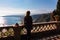 Woman with scenic view on snow capped Mount Etna volcano on sunny day from public garden Parco Duca di Cesaro in Taormina Sicily