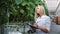 Woman science biology agronomist checking fertilize condition of cucumber seedling at greenhouse