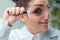 Woman scientist with eye magnified smiles