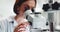 Woman, scientist and forensic discovery with microscope for science, microbiology or research at laboratory. Closeup of