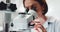 Woman, scientist and forensic research with microscope for science, microbiology or discovery at laboratory. Closeup of