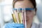 Woman scientist holding test tubes with multicolored liquids in her hands closeup