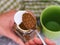 Woman scooping granulated instant coffee out of a jar with a spoon