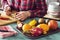 Woman Scooping Insides of Passionfruit While Preparing Tropical Fruit Salad