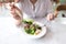 Woman scooping warm salad with spoon before eating on table in the restaurant