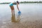 woman scooping water from river