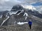 Woman  scrambling up scree  to snowcapped peak in Canadian Rockies.