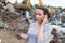 Woman in scrap yard using mobile phone