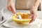 Woman scraping flesh of spaghetti squash with spoon on table