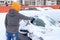 Woman scraping ice from the car window