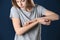 Woman scratching forearm on color background. Allergy symptom