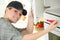 woman screwing handle on kitchen cupboard