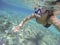 Woman scuba diving in a transparent sea