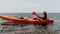 Woman sea kayak. Happy smiling woman paddling in kayak on ocean. Calm sea water and horizon in background. Active