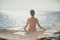 Woman sea yoga. Selective focus. Young beautiful caucasian woman in a red suit practicing yoga on the beach at sunrise