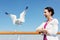 Woman and seagull on deck of ship.