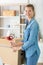 woman sealing cardboard box using tape dispenser