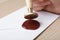 Woman sealing envelope at wooden table, closeup