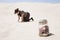 Woman searching for jar of coins in desert