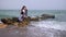 Woman at the seaside standing on beach looking out over ocean watching seagulls