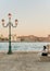 Woman seating on a bench on harbor in Venice, Italy