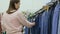 Woman in second hand store, choosing jeans