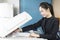 woman secretary hand putting a sheet of paper into a copying device