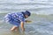 Woman seeking shells in the shallow water during low tide