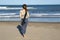 woman seen from behind, standing on the beach looking out to sea