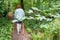 Woman seen using a hike pole, following a nature trail at a popular nature reserver during mid summer.