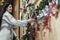 Woman selecting christmas decorations in decorative goods shop. The girl buys Christmas decorations