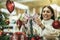 Woman selecting christmas decorations in decorative goods shop. The girl buys Christmas decorations