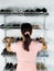 Woman selecting footwear from the shoe rack mounted on wall