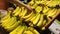 Woman selecting fresh banana in grocery store