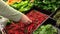 Woman selecting fresh hot chili pepper in grocery store