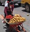 Woman selling Achiote fruits in the streets of Otavalo, Ecuador