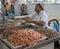 Woman selling shrimp shows motion blur in hand as she quickly loads a scale