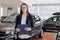 woman sells a car at a car dealership and hands over the keys to the buyer. nice woman car sales manager