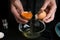 Woman separating egg yolk from white over glass bowl at table, closeup