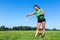 Woman serve with badminton racket and shuttle outside in grass