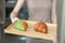 Woman serving baked crispy croissants on wooden tray