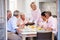 Woman Serving Cake To Group Of Friends Enjoying Meal At Home