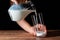 A woman serving milk into a glass cup and black background