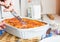 Woman serving portion of meat lasagna in the form of baking. Italian food