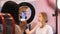 A woman setting the phone on a ring-light for a record on makeup process in the studio