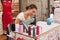 Woman with sewing machine embroidering the first name on fabric for tourists in the street