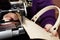 A woman sews a leather strip with a special sewing machine for leather, used in the production of handbags / shoes