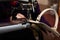 A woman sews a leather strip with a special sewing machine for leather, used in the production of handbags /shoes